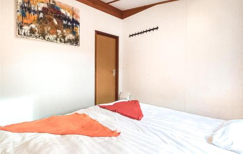 a bedroom with a bed with an orange pillow on it at Calimero in Sint Annaland