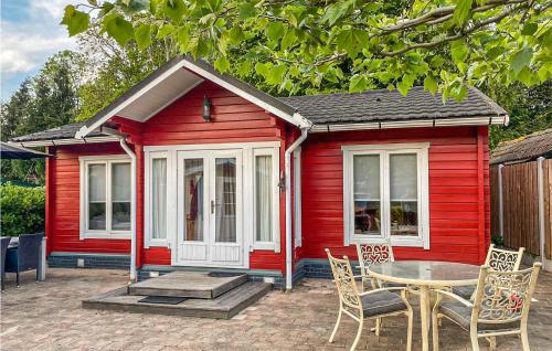 a red tiny house with a table and chairs at Nice Home In Heinkenszand With Sauna in Heinkensand
