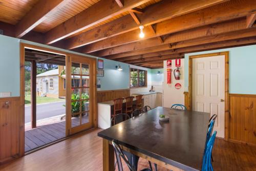 a kitchen and dining room with a table and chairs at Wairo Beach Holiday Park in Lake Tabourie