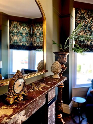 a mirror and a clock sitting on a fireplace at Lletty by Orenda-Luxe in Llandudno
