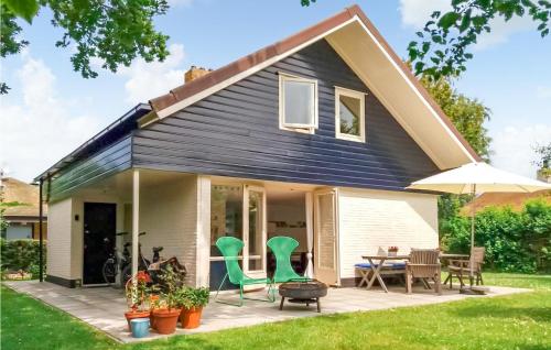 Casa con patio con sillas verdes y sombrilla en Nice Home In Brouwershaven With Wifi, en Brouwershaven