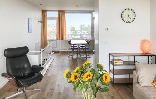 a living room with a chair and a vase of flowers at De Tuimelaar in Bergen aan Zee