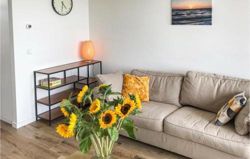 a living room with a couch and a vase of sunflowers at De Tuimelaar in Bergen aan Zee
