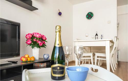 a bottle of champagne sitting on a table with glasses at 1 Bedroom Amazing Apartment In Oostende in Ostend