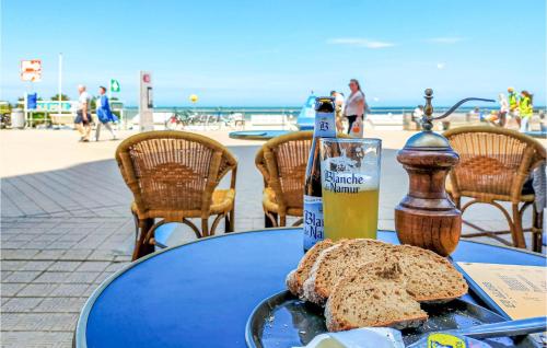 a table with a plate of bread and a bottle of beer at 1 Bedroom Amazing Apartment In Oostende in Ostend