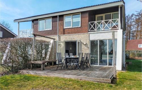 a house with a deck with a table and chairs at Awesome Home In Vlagtwedde in Vlagtwedde