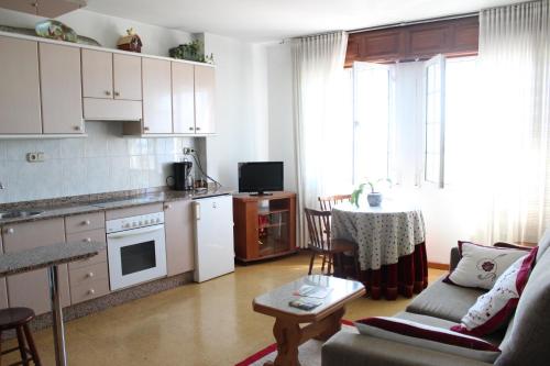 cocina y sala de estar con sofá y mesa en A Traíña, en Cambados