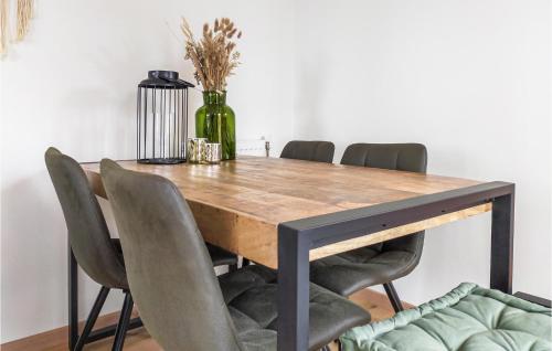 a dining room table with chairs and a vase at Pet Friendly Home In Heinkenszand in Heinkensand