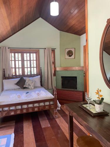 a bedroom with a bed and a fireplace at Suítes Monte Belo in Campos do Jordão