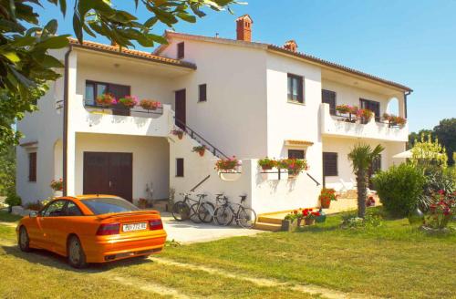 an orange car parked in front of a house at Apartment in Sisan - Istrien 41776 in Šišan