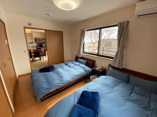 a bedroom with two beds and a window at Angel Resort Karuizawa in Karuizawa