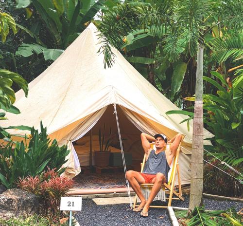 a woman is sitting in a tent at Roost Glamping - SHA Certified in Rawai Beach