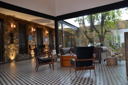 una habitación con sillas y muebles en un edificio en Quinta Tere Hotel & Gallery en Atemajac de Brizuela