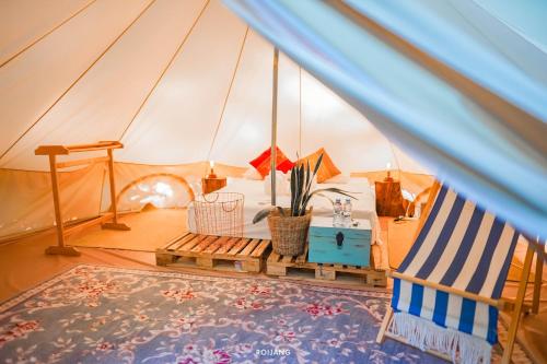 ラワイビーチにあるRoost Glamping - SHA Certifiedのテント付きの客室で、ベッドと椅子が備わります。