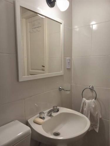 a white bathroom with a sink and a mirror at Casa Frente Parque Guillermina in San Miguel de Tucumán