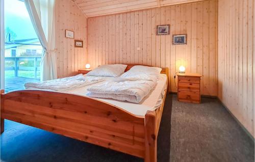 a bedroom with a wooden bed in a room with a window at Nice Home In Rechlin With Sauna in Rechlin