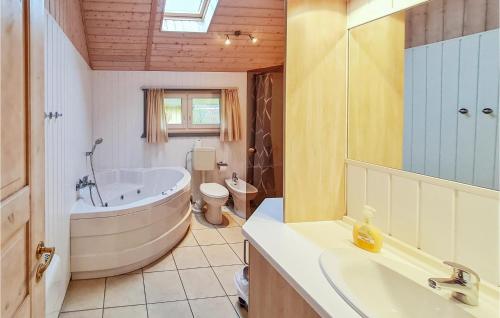 a bathroom with a tub and a toilet and a sink at Nice Home In Rechlin With Sauna in Rechlin