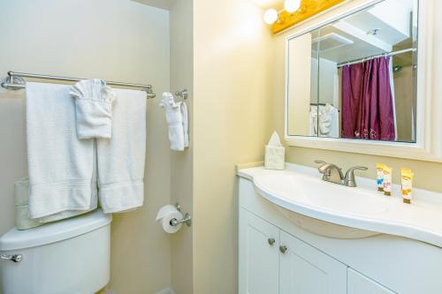 a bathroom with a toilet and a sink and a mirror at Stylish Studio with Great Ocean Views & Near Beach! in Honolulu