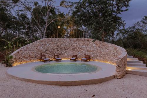 a small pool with chairs and a stone wall at Galopina in Seyé