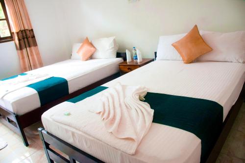 - deux lits assis l'un à côté de l'autre dans une pièce dans l'établissement The Blue Mountain Resort, à Bandarawela