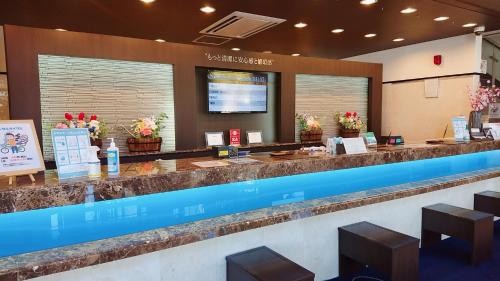 a bar in a restaurant with flowers on the counter at Toyoko Inn Fuji Kawaguchiko Ohashi in Fujikawaguchiko