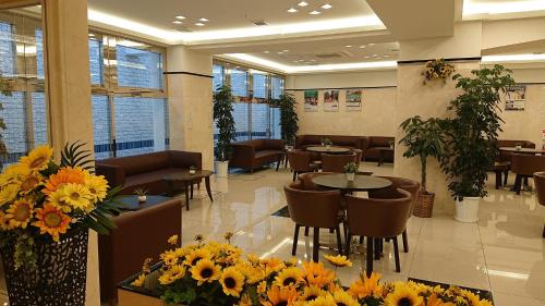 a restaurant with tables and chairs and flowers at Toyoko Inn Fuji Kawaguchiko Ohashi in Fujikawaguchiko