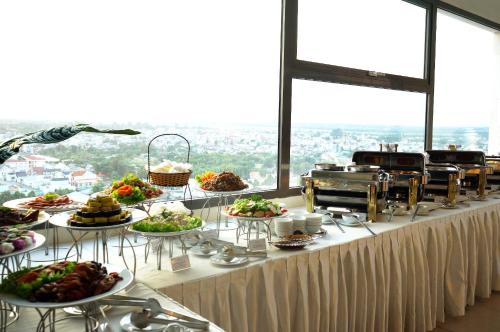 a buffet line with many plates of food on a table at AURORA Hotel Plaza in Bien Hoa