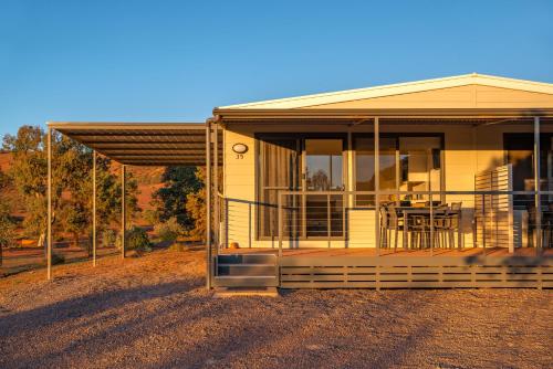 a small yellow house with a porch on a field at Rawnsley Park Station in Flinders Ranges
