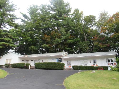 a white building with trees in the background at The Villas on Lake George in Diamond Point