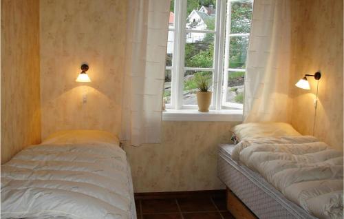 two beds in a room with a window at Beautiful Apartment In Hauge I Dalane With 2 Bedrooms And Wifi in Sogndalsstrand