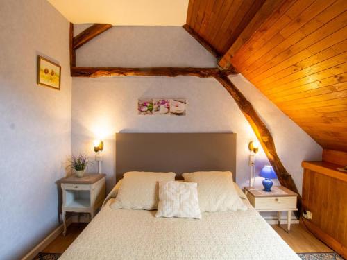 1 dormitorio con cama blanca y techo de madera en Gîte charmant avec jardin et cheminée à 2 km de Cherveix-Cubas, proche sites préhistoriques et nautiques - FR-1-616-158, en Cherveix-Cubas