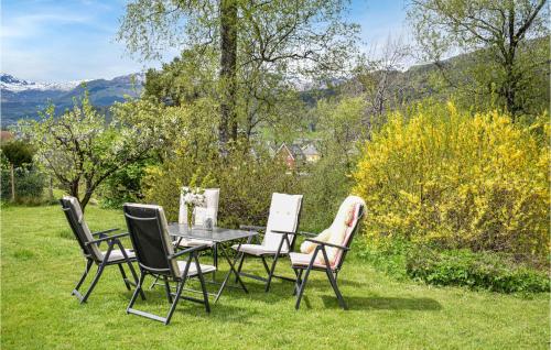 a table and four chairs in the grass at Lovely Home In Sauda With Wifi in Sauda