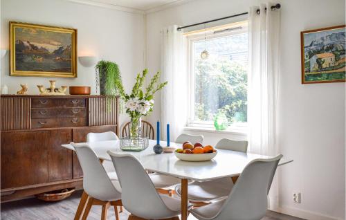 a dining room with a white table and chairs at Lovely Home In Sauda With Wifi in Sauda