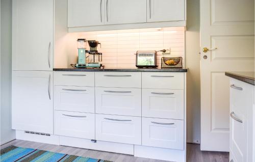 a kitchen with white cabinets and a counter at Lovely Home In Sauda With Wifi in Sauda