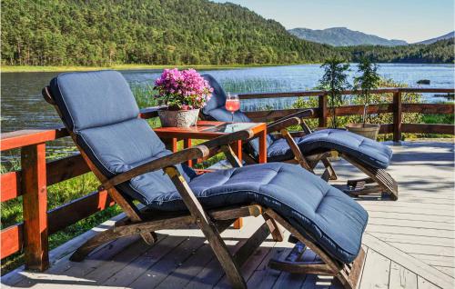 a couple of chairs sitting on a deck next to a table at Lovely Home In Bjoa With Kitchen in Utbjoa