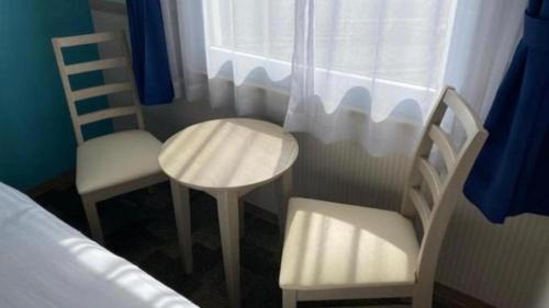a bedroom with two chairs and a table and a window at Toyoko Inn Fujisan Otsuki-eki in Ōtsuki