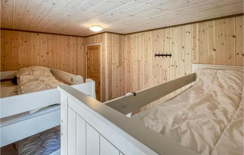 Habitación con 2 camas en una pared de madera. en 5 Bedroom Amazing Home In Nedstrand en Nedstrand