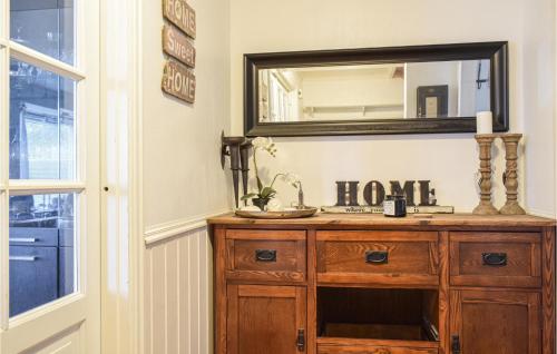 a bathroom with a wooden dresser and a mirror at Nice Home In Aksdal With House Sea View in Aksdal