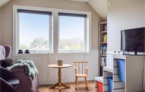 a living room with two windows and a table at Nice Home In Aksdal With House Sea View in Aksdal