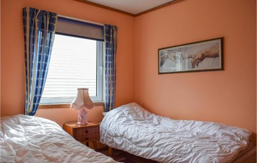 a bedroom with two twin beds and a window at Beautiful Apartment In Sævelandsvik in Sæveland