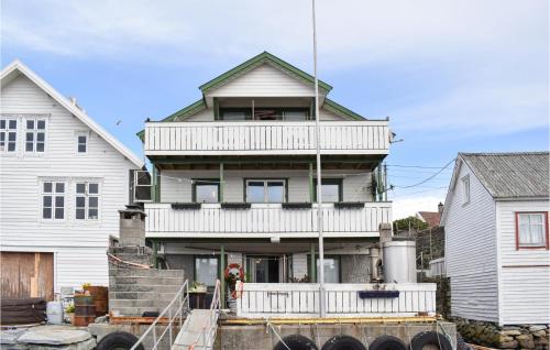 a large house with a balcony on top of it at Beautiful Apartment In Sævelandsvik in Sæveland