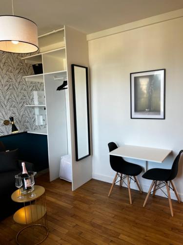 un soggiorno con un tavolo e due sedie di IDÉALEMENT SITUÉ "LE STUDIO" Les Locations ISAHORA sont aussi à 2 pas du Château d'Eu, des Falaises du Tréport, de MERS les Bains et aux portes de la BAIE DE SOMME a Eu