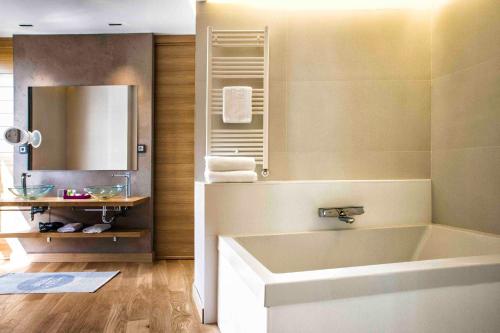 y baño con bañera y espejo. en Zenit San Sebastián, en San Sebastián
