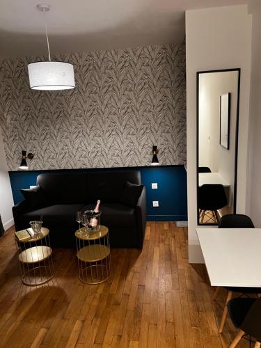 - un salon avec un canapé noir et un miroir dans l'établissement IDÉALEMENT SITUÉ 