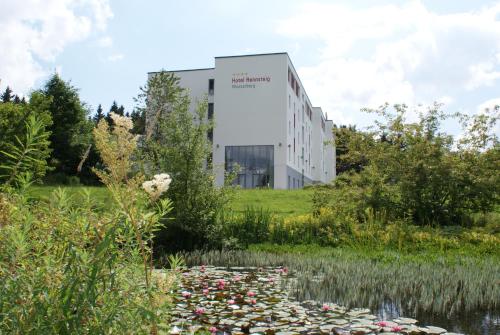 un edificio con un estanque delante de él en Hotel Rennsteig en Masserberg