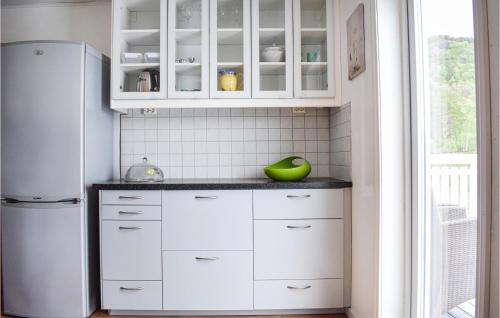 a kitchen with white cabinets and a refrigerator at Stunning Home In Seim With Wifi in Seim