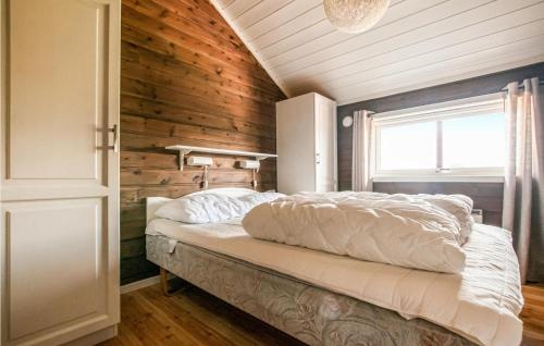 a bedroom with a bed with a wooden wall at Cozy Home In Trysil With Ethernet Internet in Mælem