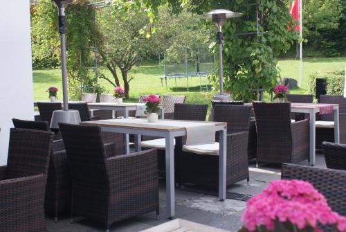 a patio with tables and chairs with flowers on it at Hotel Rennsteig in Masserberg