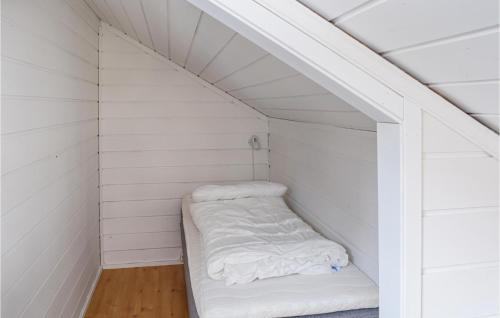a small white room with a bed in the attic at Alpinhytte 1 in Favang