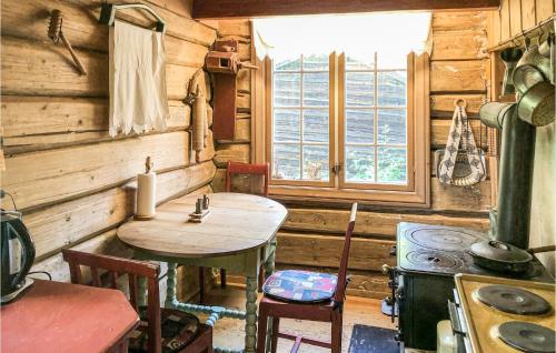 a kitchen with a table and a stove in a cabin at Nice Home In Vinstra With House A Mountain View in Vinstra